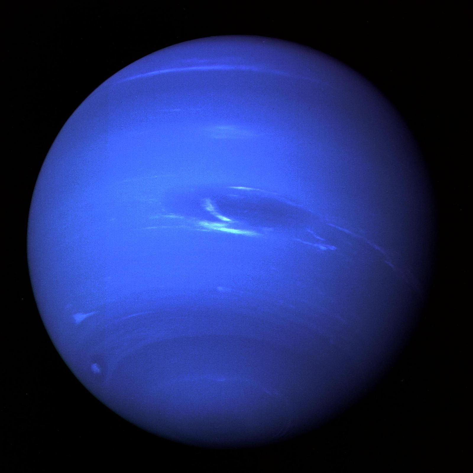 Neptune as a deep blue globe with the dark oval Great Dark Spot and streaks of white clouds